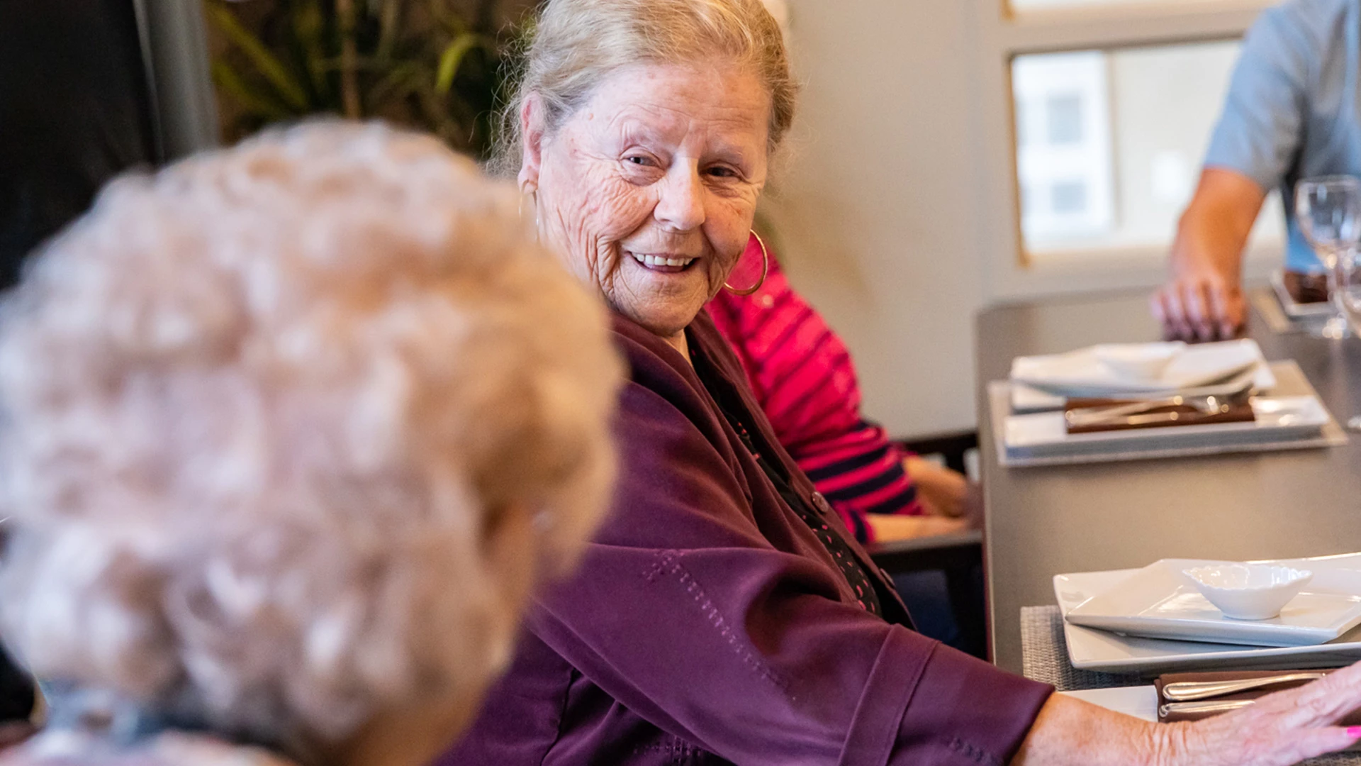 lady smiling and laughing with someone at a table