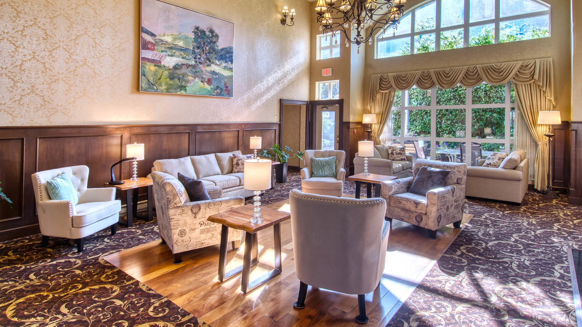 Chairs in a common room with big windows and sun shining through